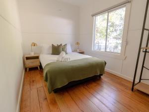 a bedroom with a large bed and a window at Charlie's Beach House in Byron Bay