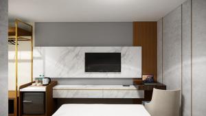 a bedroom with a bed and a tv on a wall at d'primahotel Airport Jakarta Terminal 3 Wellness Center in Tangerang