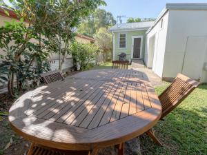 a wooden table and chairs in a yard at Charlie's Beach House in Byron Bay