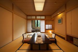 ein Zimmer mit einem langen Tisch und Stühlen in der Unterkunft Hodakaso Yamano Hotel in Takayama