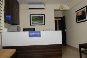 班加罗尔The Altruist Business Stays, Manayata Tech Park的带有标志的房间的前台