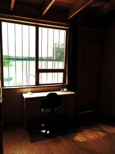 una scrivania con sedia di fronte a una finestra di Estudio familiar en casa campestre a Città del Messico