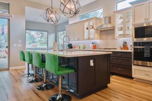 a kitchen with a large island with green bar stools at Sedona Desert Modern - Hot Tub & Views in Sedona