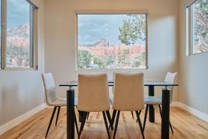 a dining room with a table and chairs in front of a window at Sedona Desert Modern - Hot Tub & Views in Sedona