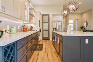 a large kitchen with blue cabinets and wooden floors at Sedona Desert Modern - Hot Tub & Views in Sedona