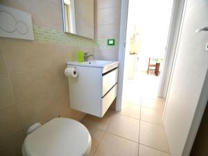 Łazienka z białą toaletą i umywalką w obiekcie Charming Apartment In Central Location With Air Conditioning Pets w mieście Torre dell'Orso