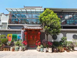 丽江丽江妈妈纳西家庭客栈的一座建筑,前面有一扇有植物的门
