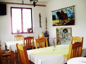 une salle à manger avec deux tables et un tableau mural dans l'établissement Pansion Izvor, à Korenica