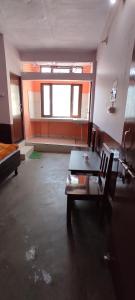 um quarto vazio com uma mesa e uma cadeira em Gomukh Home Stay em Uttarkāshi