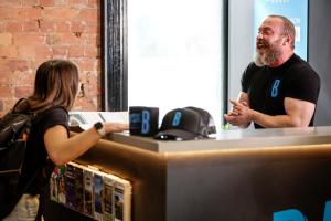 a man standing at a counter talking to a woman at Bayside House in Melbourne