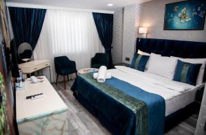 a hotel room with a large bed and a desk at Essam Deluxe Hotel in Baku