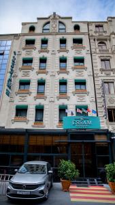 巴庫的住宿－Essam Deluxe Hotel，停在大楼前的汽车