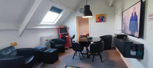 ein Zimmer mit einem Wohnzimmer mit einem Tisch und Stühlen in der Unterkunft Penthouse 40 m2 in Zemst
