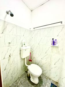 Isyfaq Homestay 2 bedroom & 2 bathroom في كوتا تينجي: حمام مع مرحاض أبيض في الغرفة