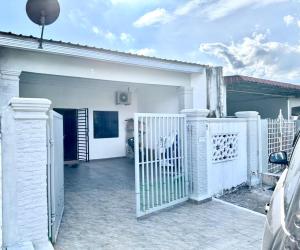 uma cerca branca em frente a uma casa branca em Isyfaq Homestay 2 bedroom & 2 bathroom em Kota Tinggi