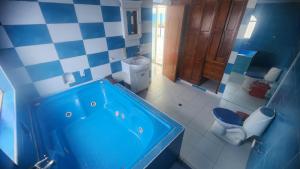 a bathroom with a blue tub and a toilet at Hotel spa la buena vida in Fusagasuga
