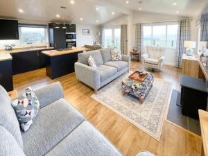 a living room with two couches and a kitchen at Kilda View in Berneray