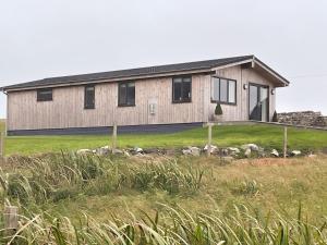 a house with a herd of sheep in front of it at Kilda View in Berneray