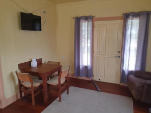 Una sala de estar con una mesa y sillas y un televisor. en Drovers Retreat, en Thulimbah 9 fotos más