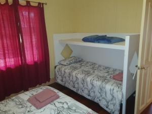 Un dormitorio con dos camas y una cortina roja. en Drovers Retreat, en Thulimbah