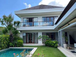 uma casa com uma piscina em frente em Oshan Villas Bali em Canggu