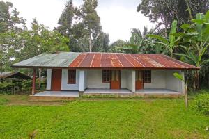 una pequeña casa con un techo de estaño oxidado en SPOT ON 92567 Jati Homestay, en Lombok