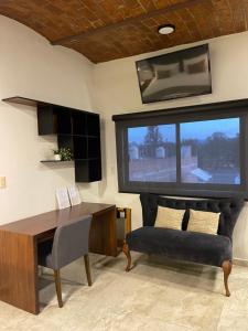 a living room with a desk and a large window at Hotel NG in Ameca
