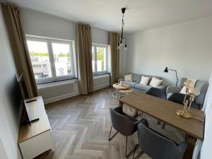 een woonkamer met een bank en een tafel bij Airport Apartments for 4 - Kitchen - Parking with eCharging in Hamburg