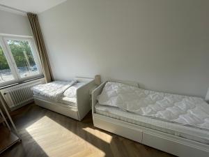 um quarto com 2 camas e uma janela em Airport Apartments for 4 - Kitchen - Parking with eCharging em Hamburgo