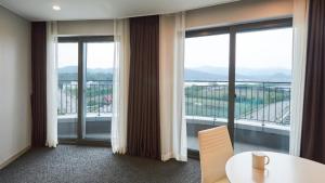 a room with a table and views of a balcony at Chuncheon Eston Hotel in Chuncheon