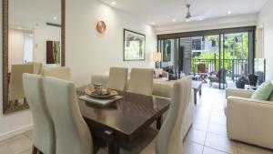 comedor y sala de estar con mesa y sillas en Sea Temple 125 Port Douglas, en Port Douglas