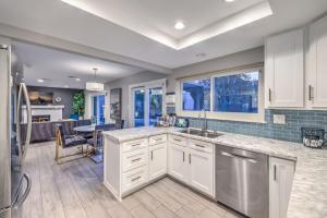 a kitchen with white cabinets and a large window at Vegas Pool w Wetdeck, Jacuzzi, Wetbar, BBQ, 15 min to Strip in Las Vegas