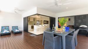 ein Wohnzimmer mit Tisch und ein Esszimmer in der Unterkunft Cascade Drive Port Douglas in Craiglie