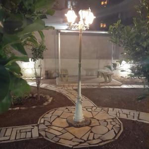 a light pole in the middle of a garden at casa zervos - Abode of Light in Loutraki