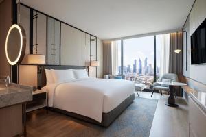 a hotel room with a bed and a view of a city at dusitD2 Samyan Bangkok in Bangkok