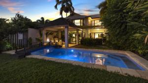 a house with a swimming pool in front of a house at Catalina Port Douglas in Port Douglas