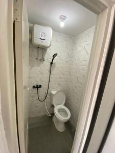 ein kleines Bad mit einem WC und einer Dusche in der Unterkunft POP Exclusive - Female Only in Jakarta