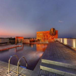 a pool on the roof of a building at night at The Quorum in Mysore