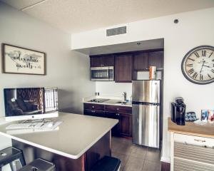 a kitchen with a refrigerator and a clock on the wall at Water Street Retreat 14 in Wilmington
