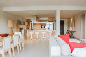 a living room with a white couch and a kitchen at La Balise Marina by Horizon Holidays in Tamarin