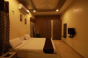 een slaapkamer met een bed en een televisie. bij royal stay in Madurai