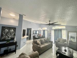a living room with a couch and a ceiling fan at Grand Superior 4BR Pool House near Disney Parks in Davenport