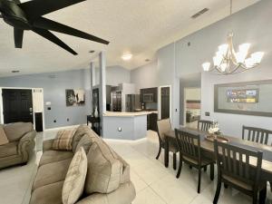 a living room with a couch and a dining room at Grand Superior 4BR Pool House near Disney Parks in Davenport