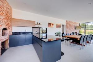 a kitchen with a dining table and a brick wall at CASALE ESTATE in Nuriootpa