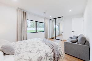 a white bedroom with a bed and a couch at CASALE ESTATE in Nuriootpa