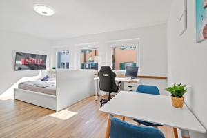 a studio apartment with a bed and a desk and chairs at City Center-Twin Bed-Coffee-Workplace-Washer in Winterthur