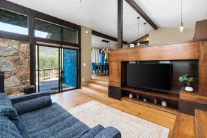 sala de estar con sofá azul y TV en Mountain View, Hot Tub, Open Kitchen, 10m to Sequoia en Three Rivers