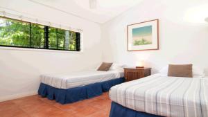 Duas camas num quarto com uma janela em On The Beach 3 Port Douglas em Port Douglas