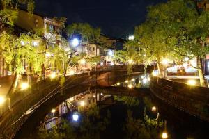 a bridge over a river at night with lights at Oyado Seri in Toyooka