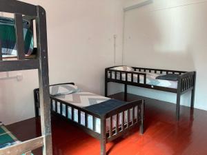 a room with three bunk beds in a room at Travellers Diary Guesthouse in Melaka